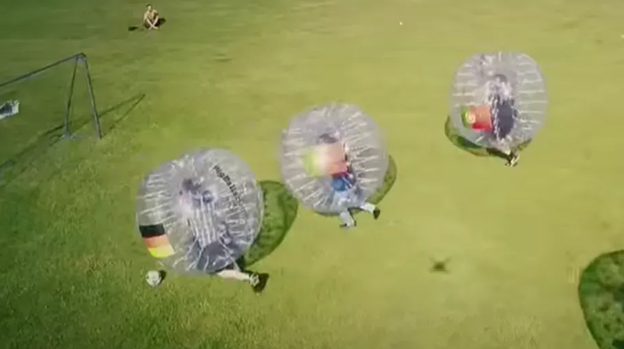 Eine Gruppe spielt draußen Bubble Soccer