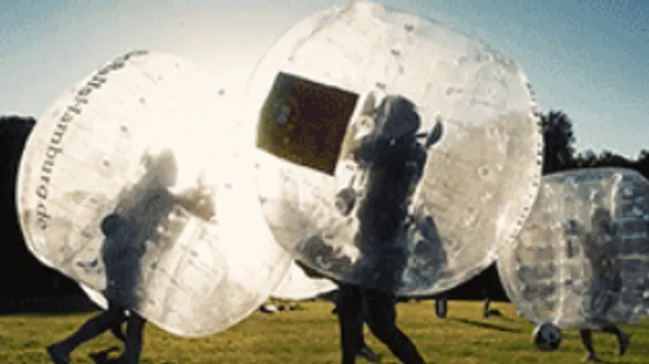 Eine Gruppe spielt Bubble-Soccer draußen