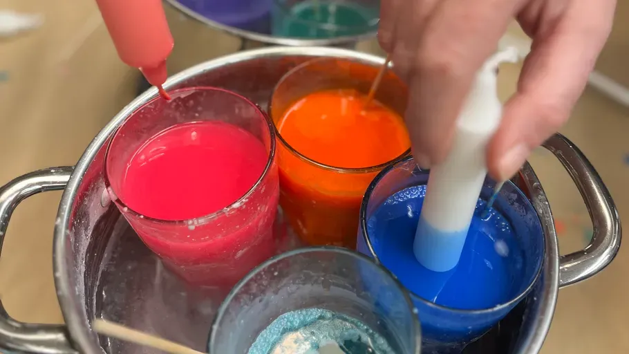 Kerzen werden in Wachs getunkt