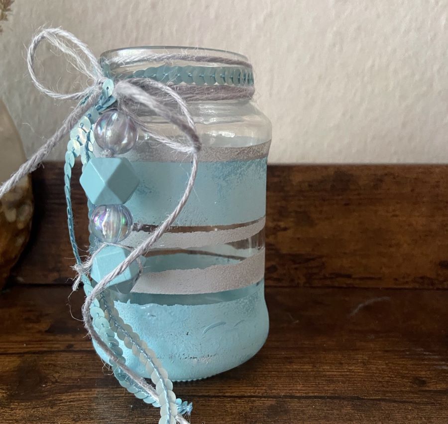 Ein Windlicht in blau und weiß  mit Schleifen