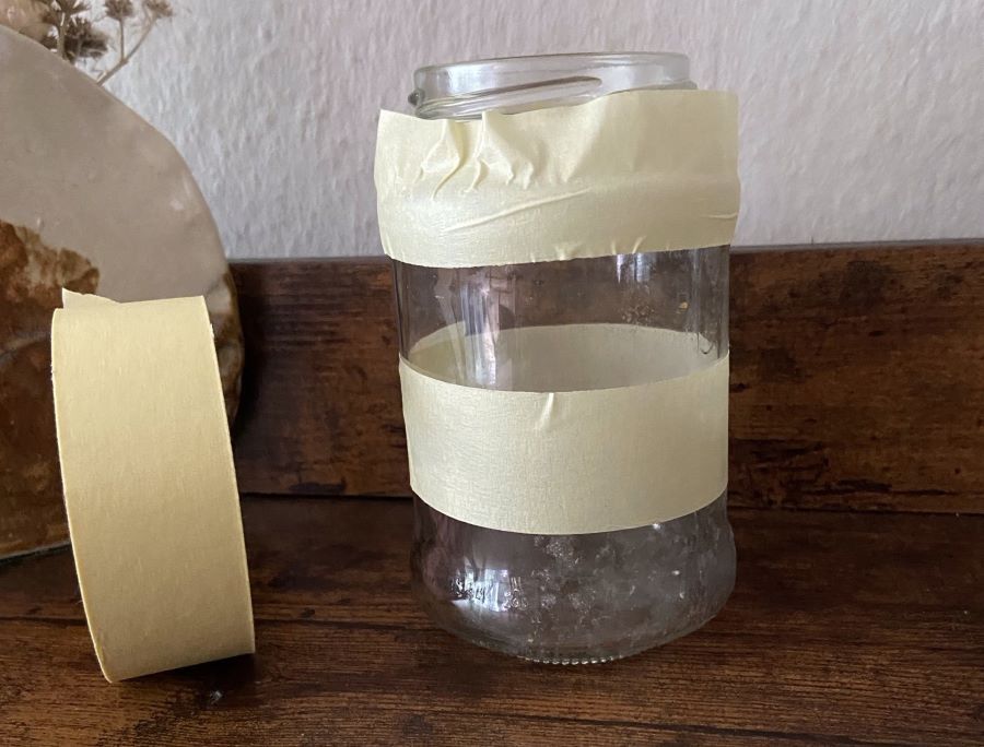 Ein Glas mit Tape und eine Taperolle