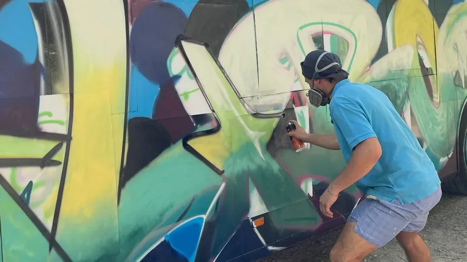 Ein Mann sprayt ein Graffiti