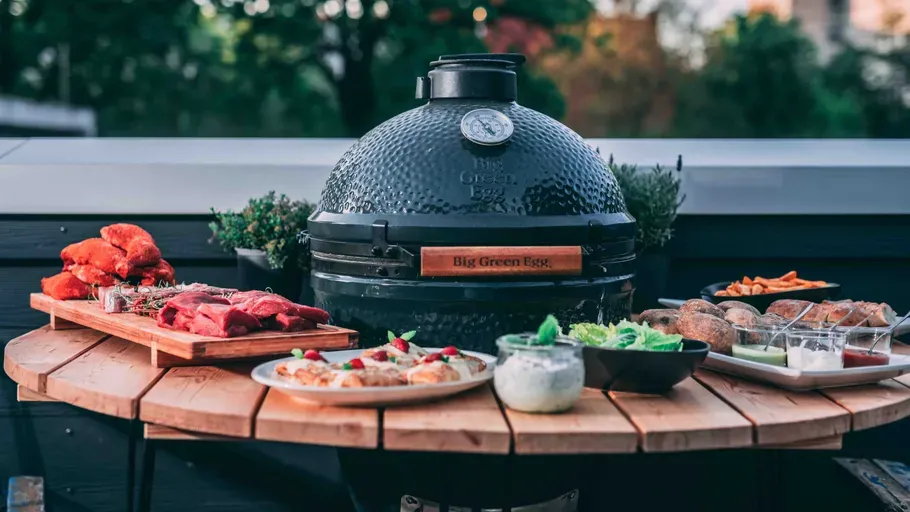 Ein Kamado Grill und zubereitete Speisen vom Grill. 