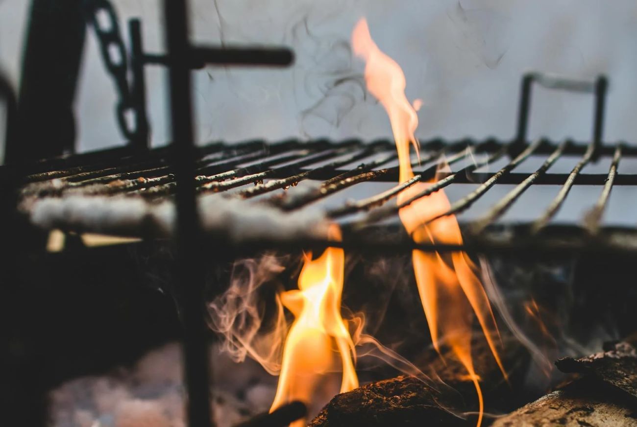 Schwenkgrill über brennendem Holz