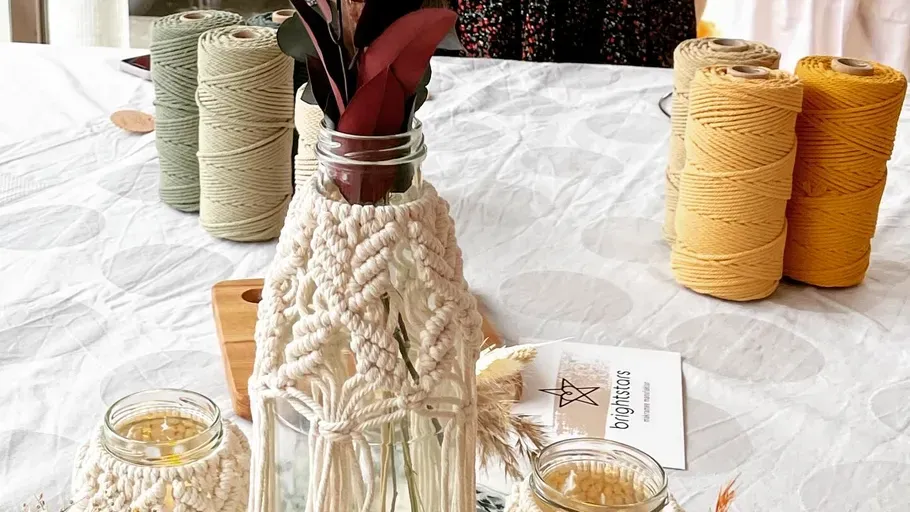 Makramee Garn und Makramee-Deko stehen auf einem Tisch.