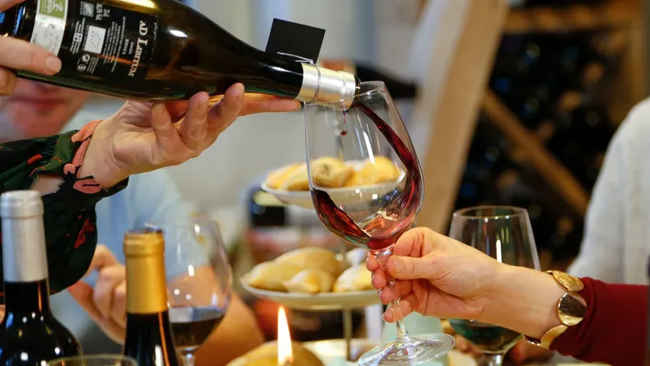 Rotwein wird in ein Weinglas eingegossen
