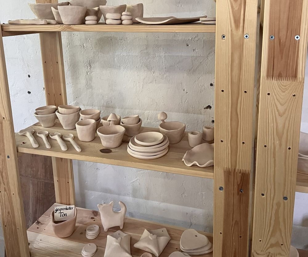 Schrank mit getöpferten Schalen und Tassen.