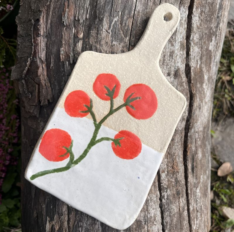 Keramik-Frühstücksbrett mit Tomaten.