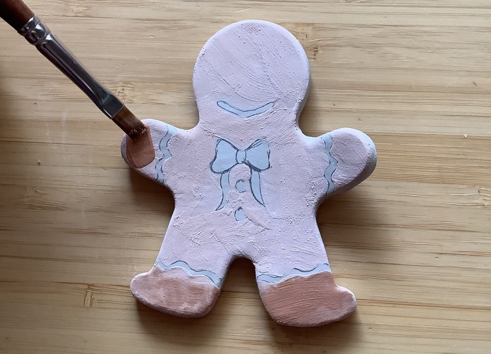 Lebkuchenfigur aus Keramik wird bemalt.
