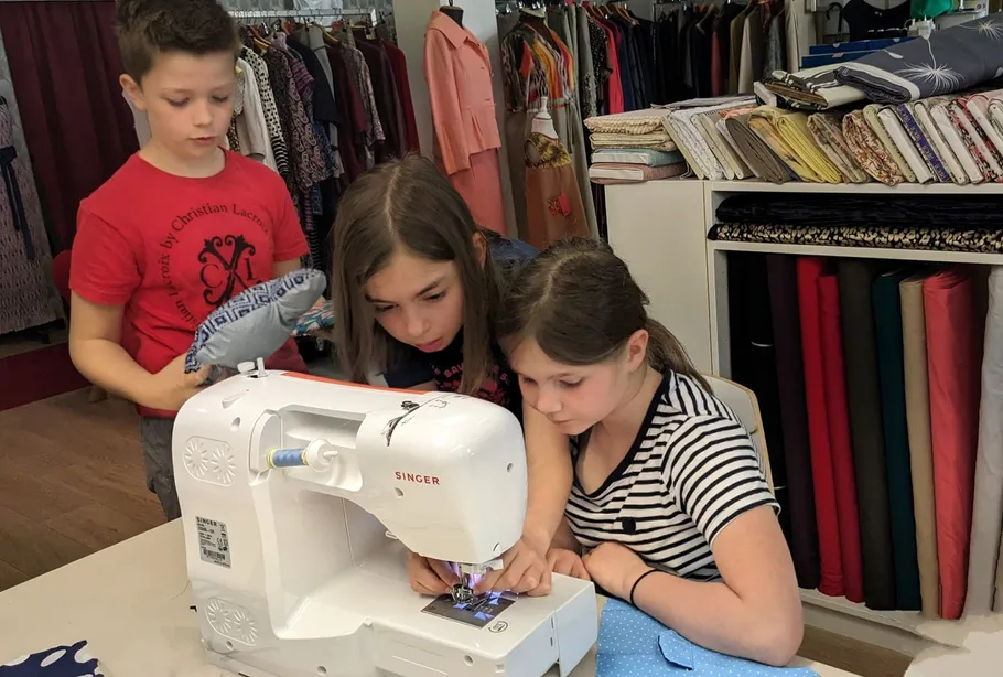 Kinder nähen gemeinsam bei einem Kindergeburtstag in Dresden.