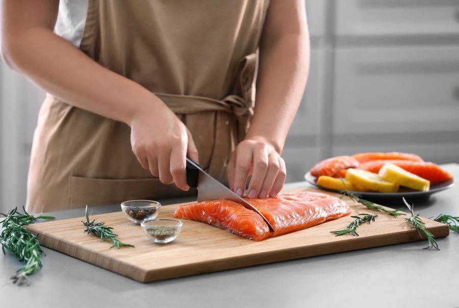 Eine Person schneidet Lachs