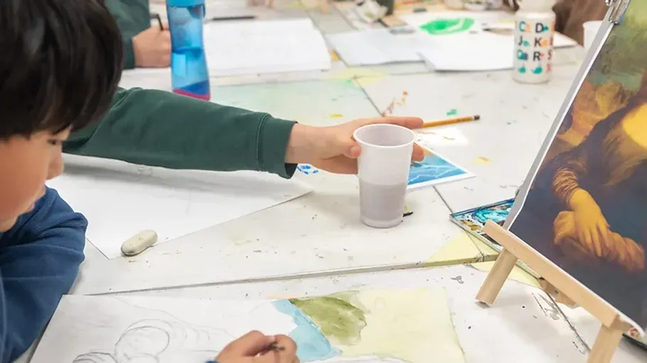 Kinder malen auf einer Leinwand.