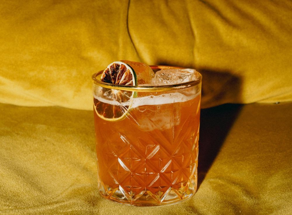 Mai Tai Cocktail auf einem gelben Sofa.