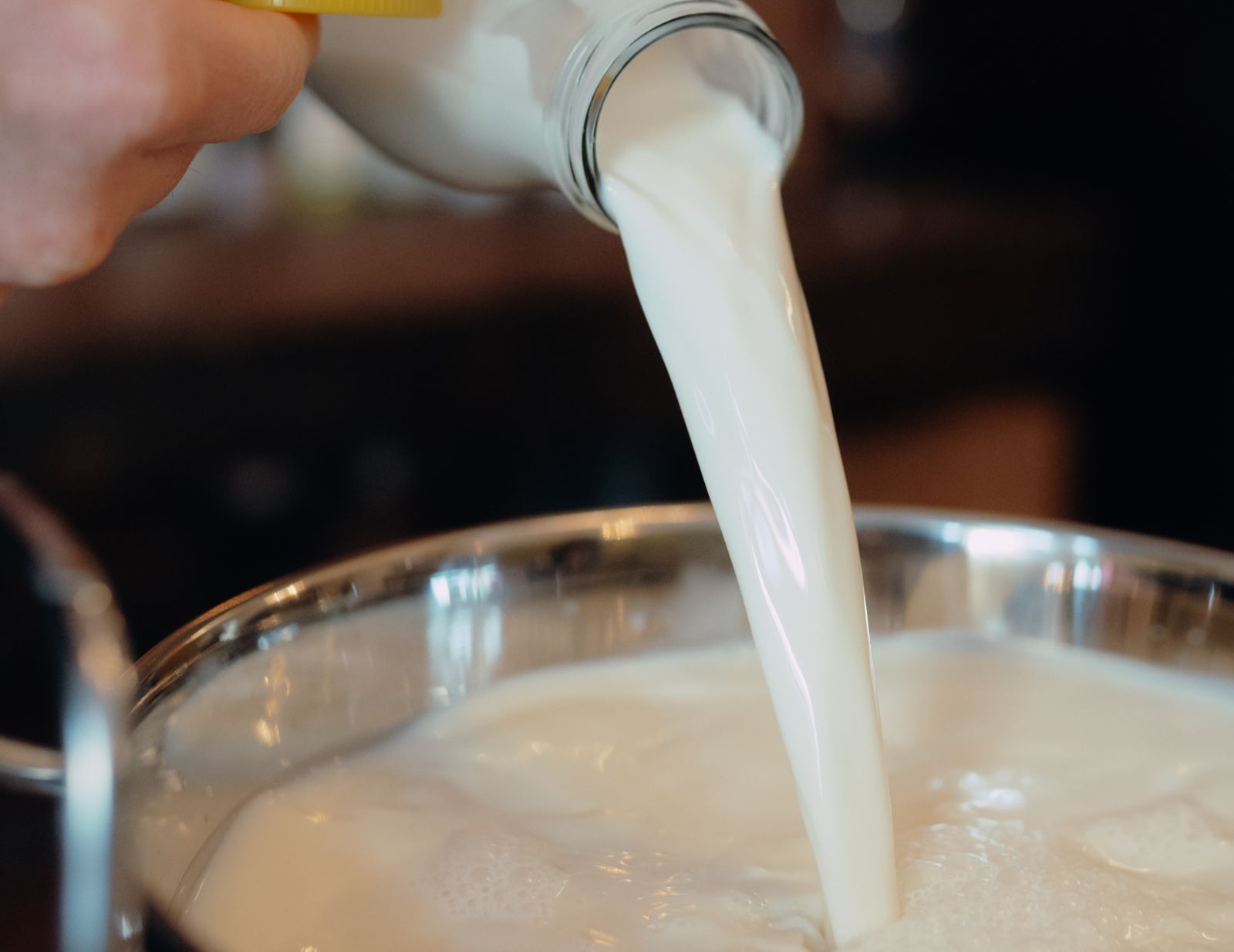 Milch wird in einen Topf gegossen.