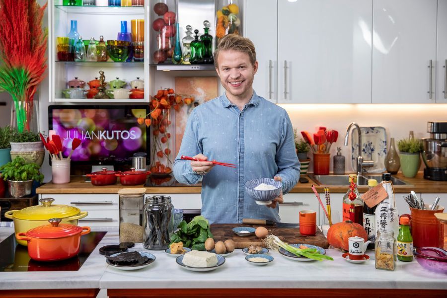 Ein Koch steht an einer Kücheninsel und kocht Ramen.