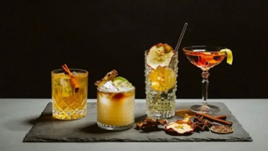 Vier verschiedene Cocktails auf einer Schieferplatte