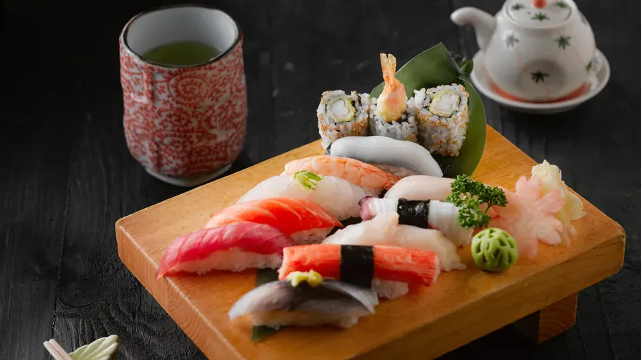 Sushi und grüner Tee stehen auf einem Tisch