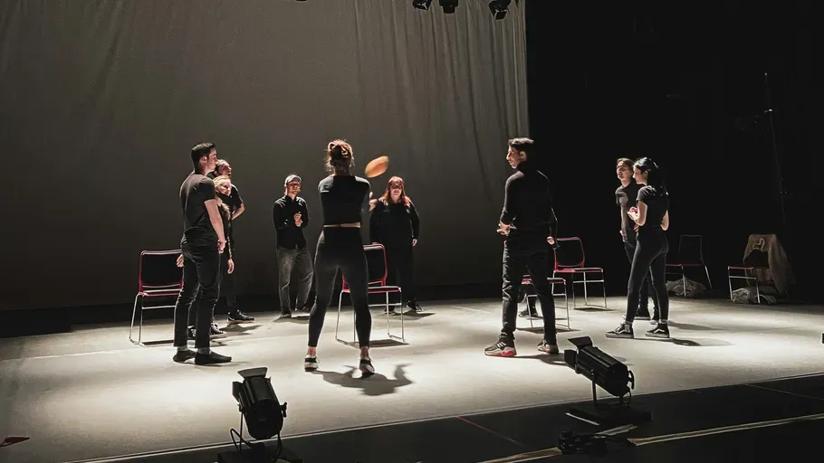 Personen im Kreis auf einer Theaterbühne