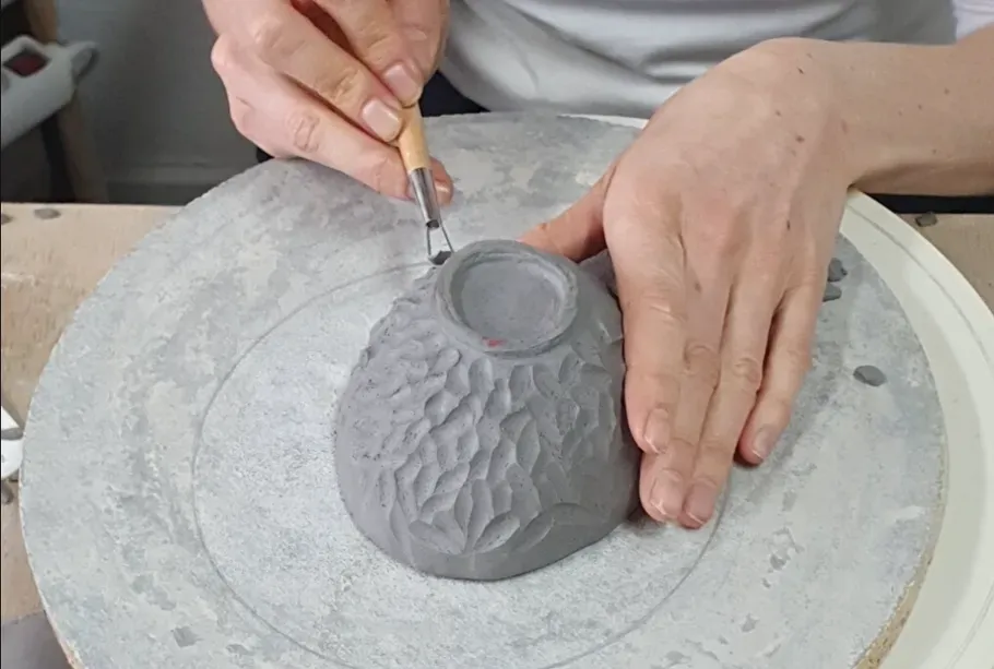 Eine Person töpfert eine Schüssel