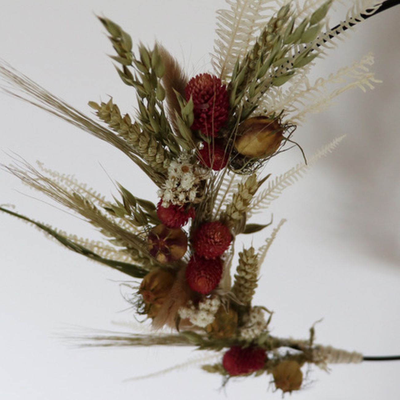 Trockenblumenkranz mit roten Blüten.