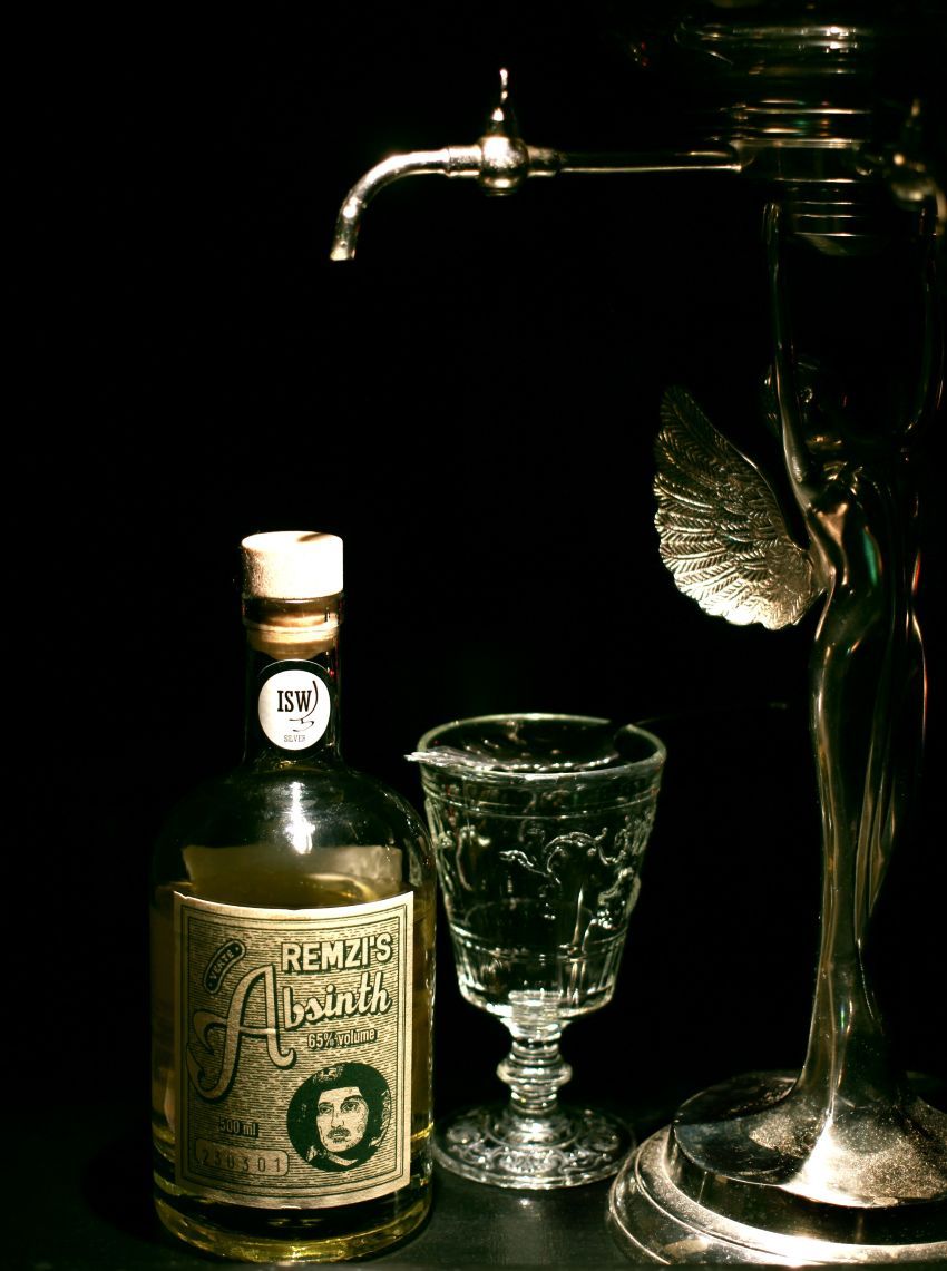 Absinthflasche und Glas stehen nebeinander.