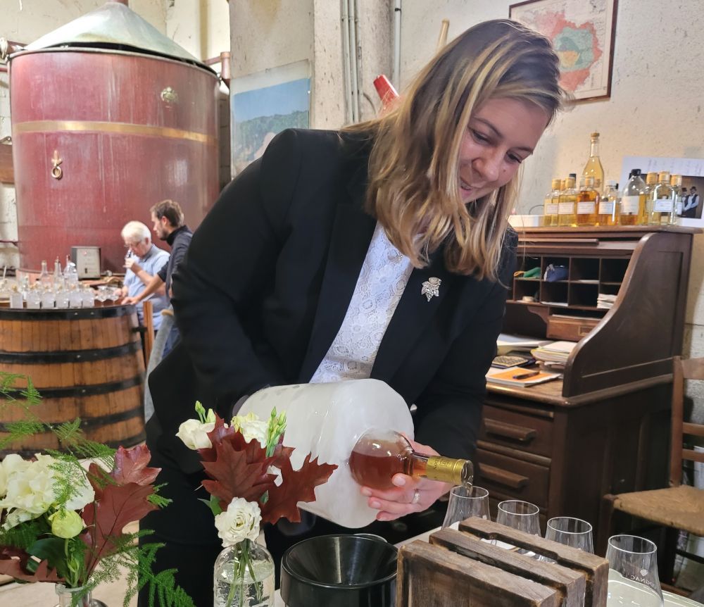 Eine Frau gießt Cognac in Gläser.