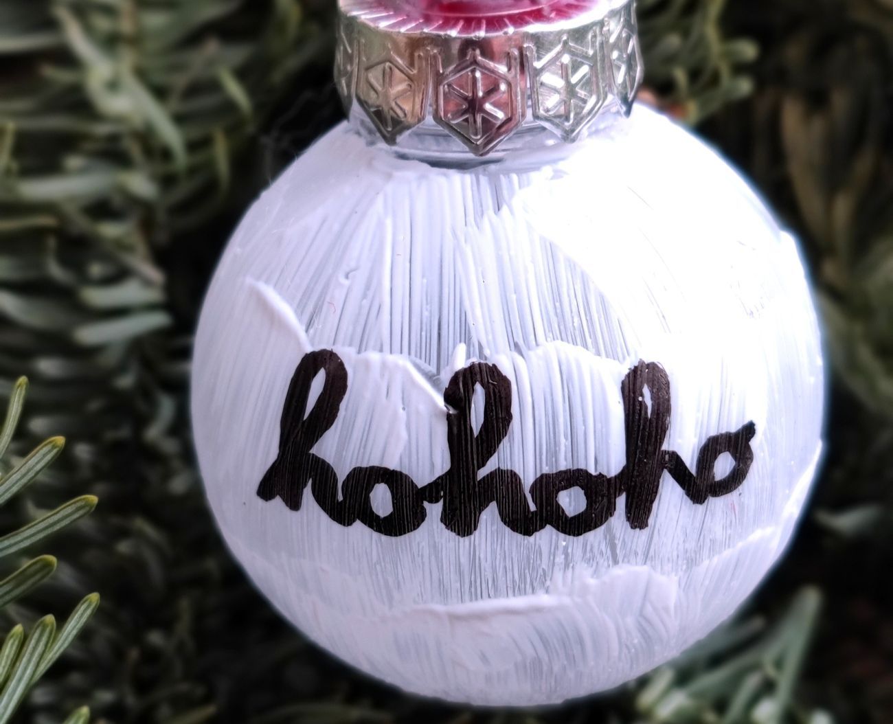 Weiß bemalte Weihnachtskugel.