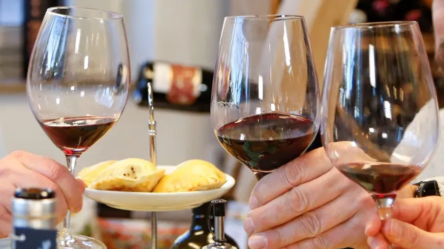 Weingläser mit Rotwein und Essen auf einem Tisch